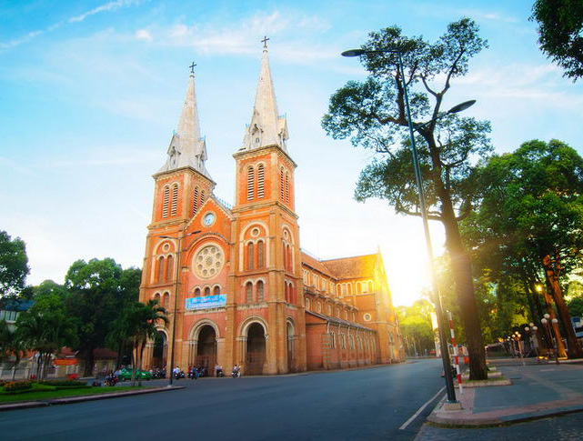 Notre-Dame Cathedral Basilica of Saigon in Ho Chi Minh City with French colonial architecture and twin bell towers at sunrise.