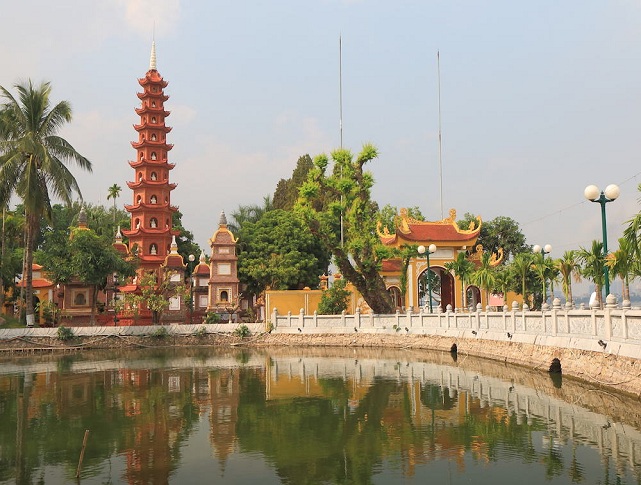 Tran Quoc Pagoda in Hanoi standing beside West Lake with traditional Vietnamese Buddhist architecture.