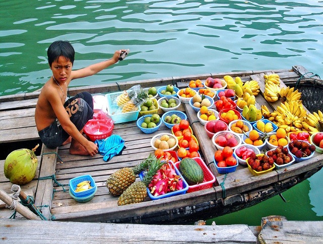 Boats filled with fresh fruits and local goods at a colorful floating market in the Mekong Delta, Vietnam