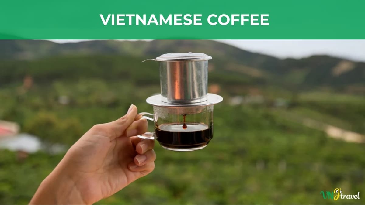 A hand holding a traditional Vietnamese coffee phin filter over a glass of dark coffee, with a green landscape in the background and the title “VIETNAMESE COFFEE” at the top.