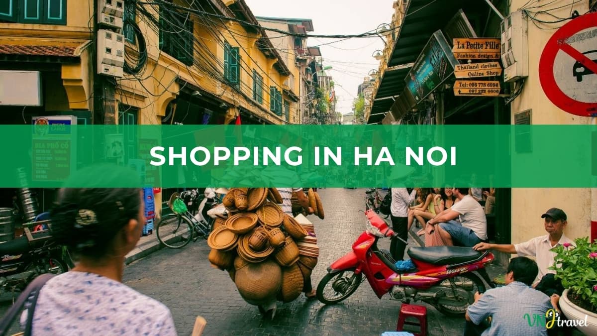 An active street scene in Hanoi's Old Quarter with locals, tourists, parked motorbikes, and vendors carrying woven baskets, overlaid with a green banner reading "SHOPPING IN HA NOI"