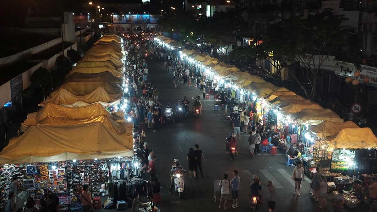 Ben Thanh Night Market in Ho Chi Minh City bustling with shoppers, illuminated vendor stalls, street food stands, and lively evening crowds.