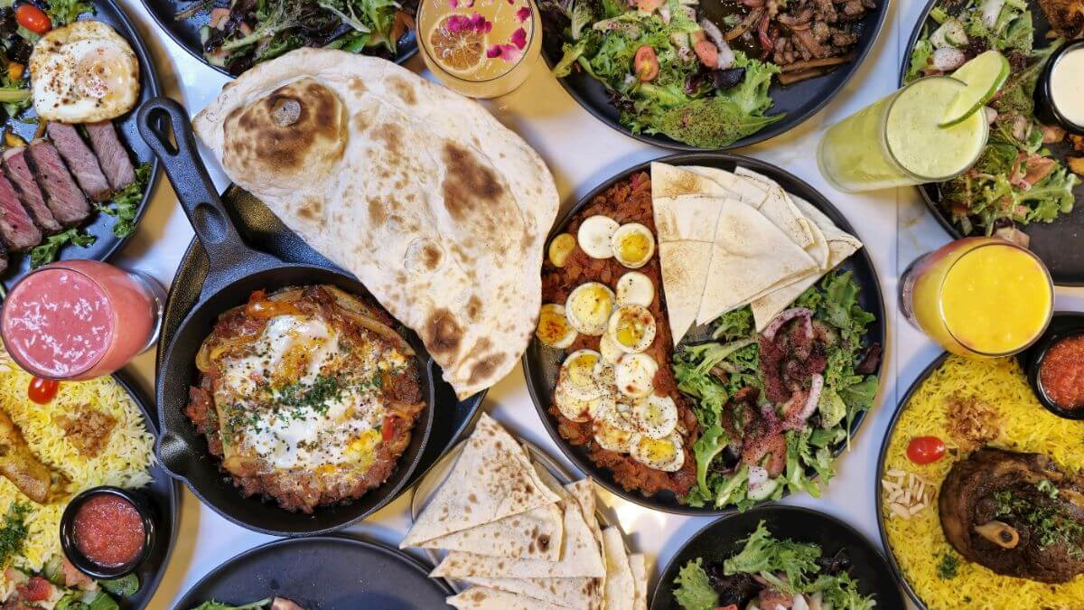 A selection of halal food dishes featuring grilled meats, aromatic rice, fresh vegetables, flatbread, and traditional Middle Eastern seasonings served on a dining table.