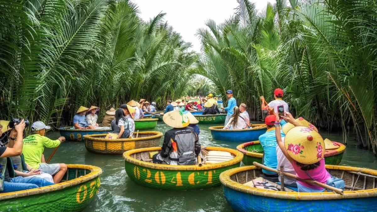 Visitors ride traditional basket boats through the lush coconut palm waterways of Bay Mau Coconut Forest in Hoi An, Vietnam.