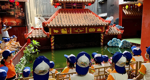 Children watching a traditional water puppet show in Vietnam