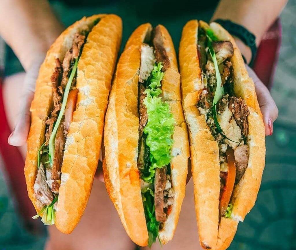 Traditional Vietnamese bánh mì sandwiches filled with meat, pickled vegetables, herbs, and fresh ingredients.