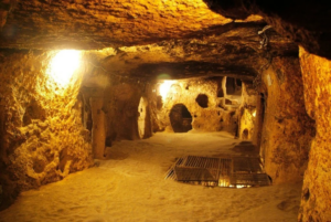 nterior view of the Cu Chi Tunnels with narrow underground passageways illuminated by warm lights.