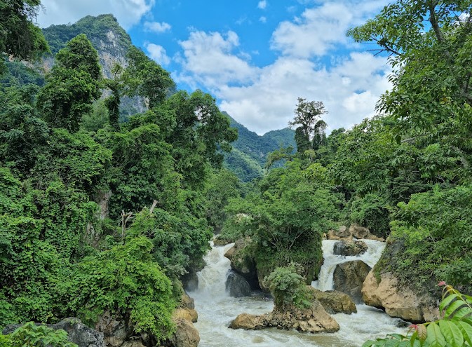 Dau Dang Waterfall surrounded by lush forest and rocky landscape in Ba Be National Park, Vietnam