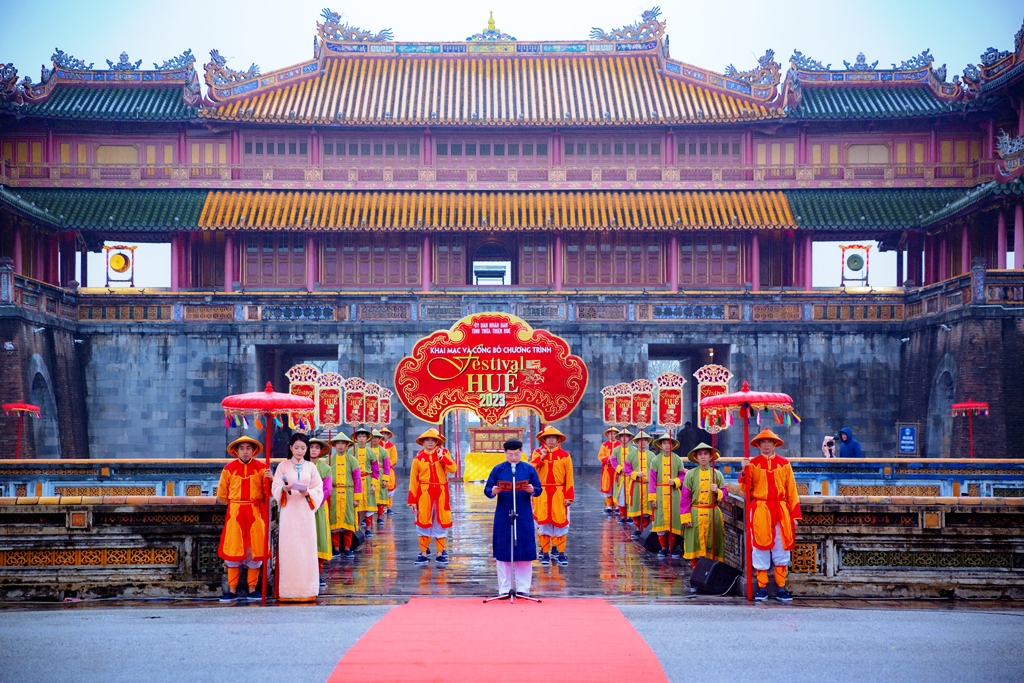 Performers in traditional royal costumes standing in front of the Imperial City during the Hue Festival in Vietnam.