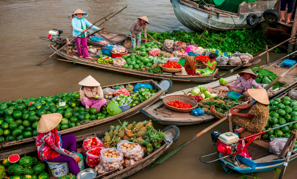 Colorful boats selling fruits and vegetables at a floating market in the Mekong Delta, Vietnam.