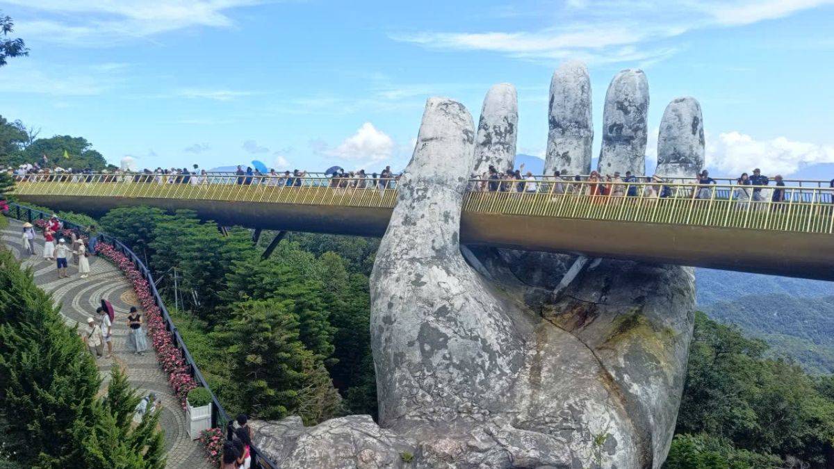 Golden Bridge in Ba Na Hills, Da Nang, Vietnam, featuring the iconic giant stone hands supporting the pedestrian bridge above lush mountain landscapes.