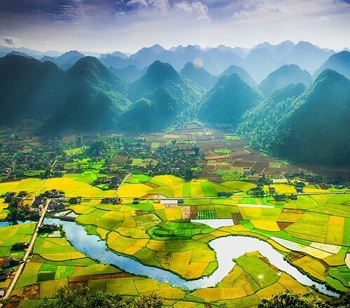 Aerial view of green rice fields and limestone mountains in Lang Son, northern Vietnam.