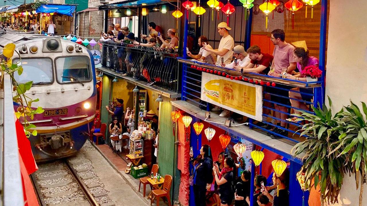 Hanoi Train Street in the Old Quarter with colorful cafes and a train track running through a narrow street in Hanoi, Vietnam