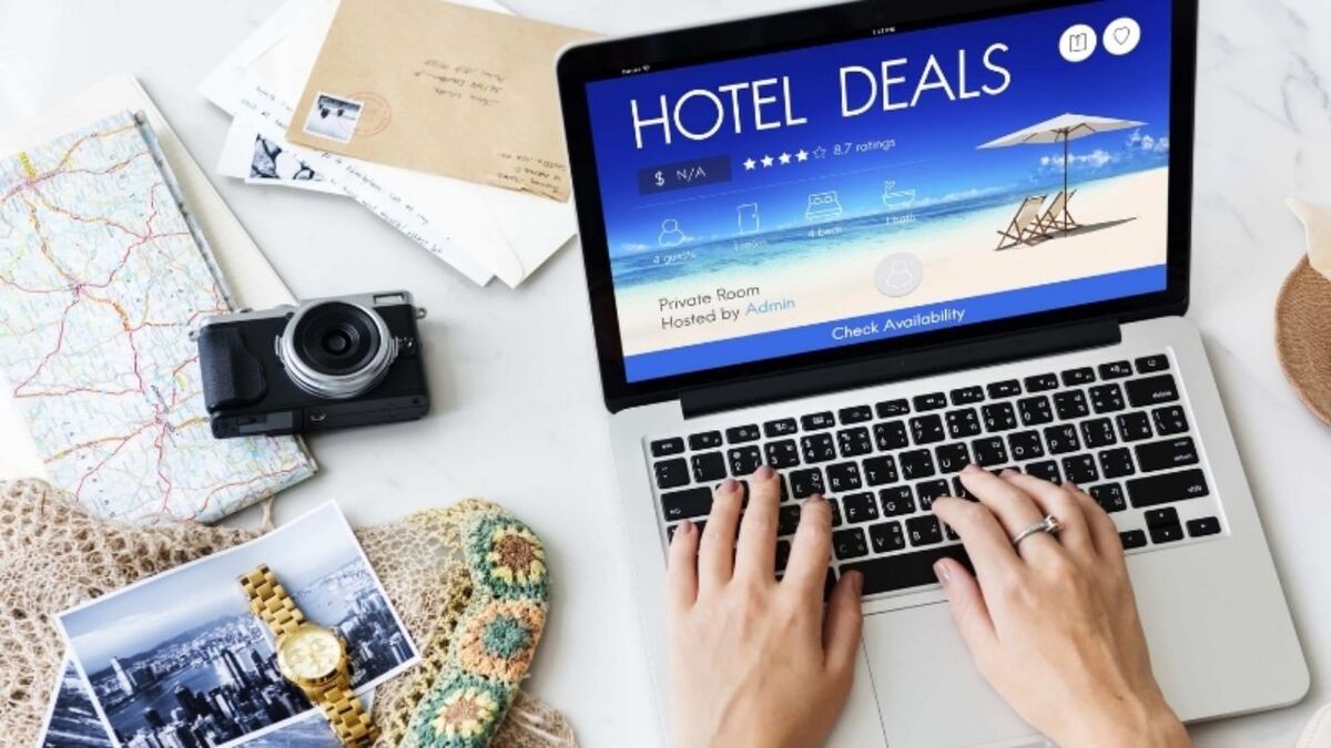 Traveler booking a hotel online on a laptop, illustrating the risk of hotel deal scams and fake accommodation offers when planning a trip.