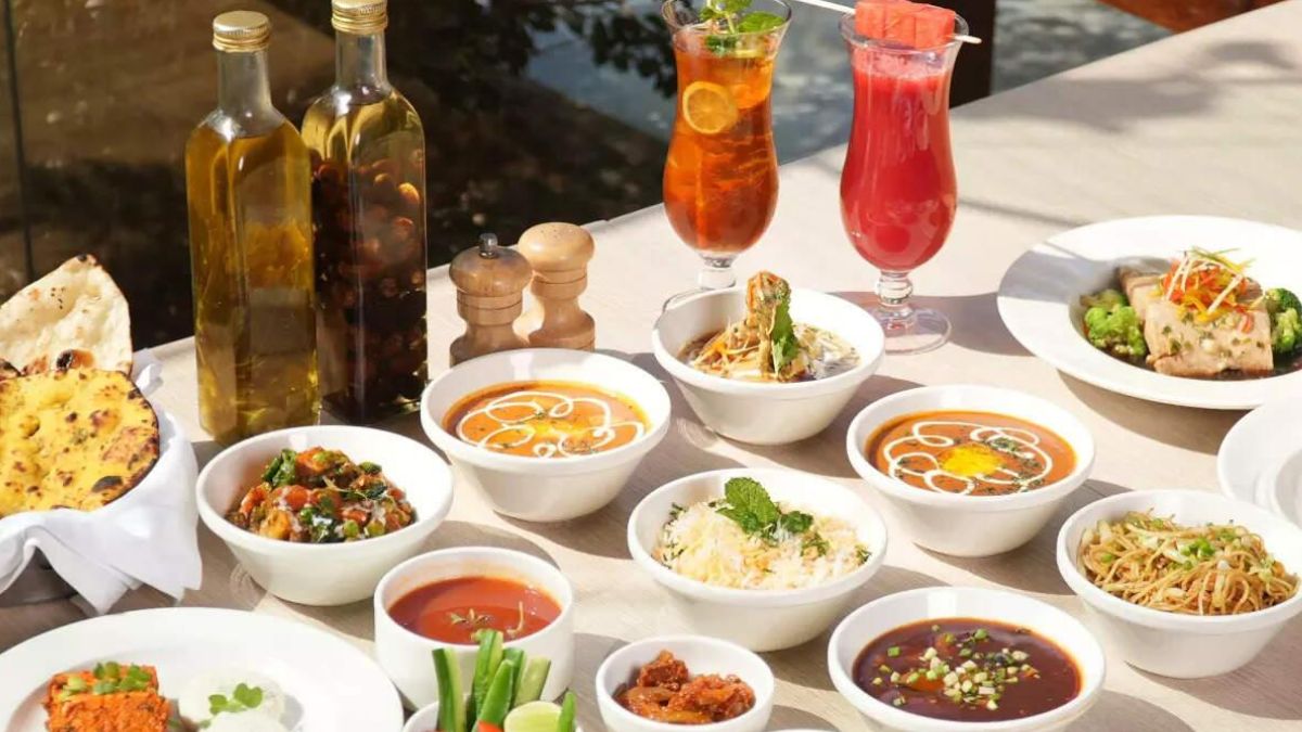 Flavorful Indian dining spread featuring creamy curry, freshly baked naan, tandoori chicken, aromatic biryani rice, and refreshing beverages.