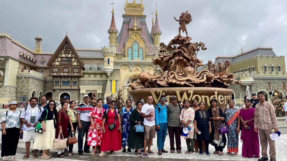 A group of Indian tourists posing for a photo in front of the iconic fountain and castle at Sun World Ba Na Hills in Da Nang, Vietnam.
