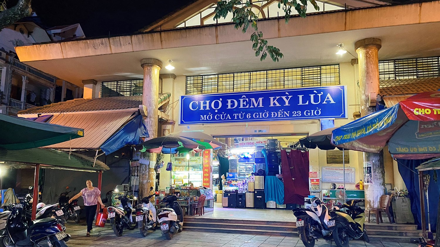 Ky Lua Night Market in Lang Son illuminated at night with local shops, motorbikes, and colorful market stalls welcoming visitors.