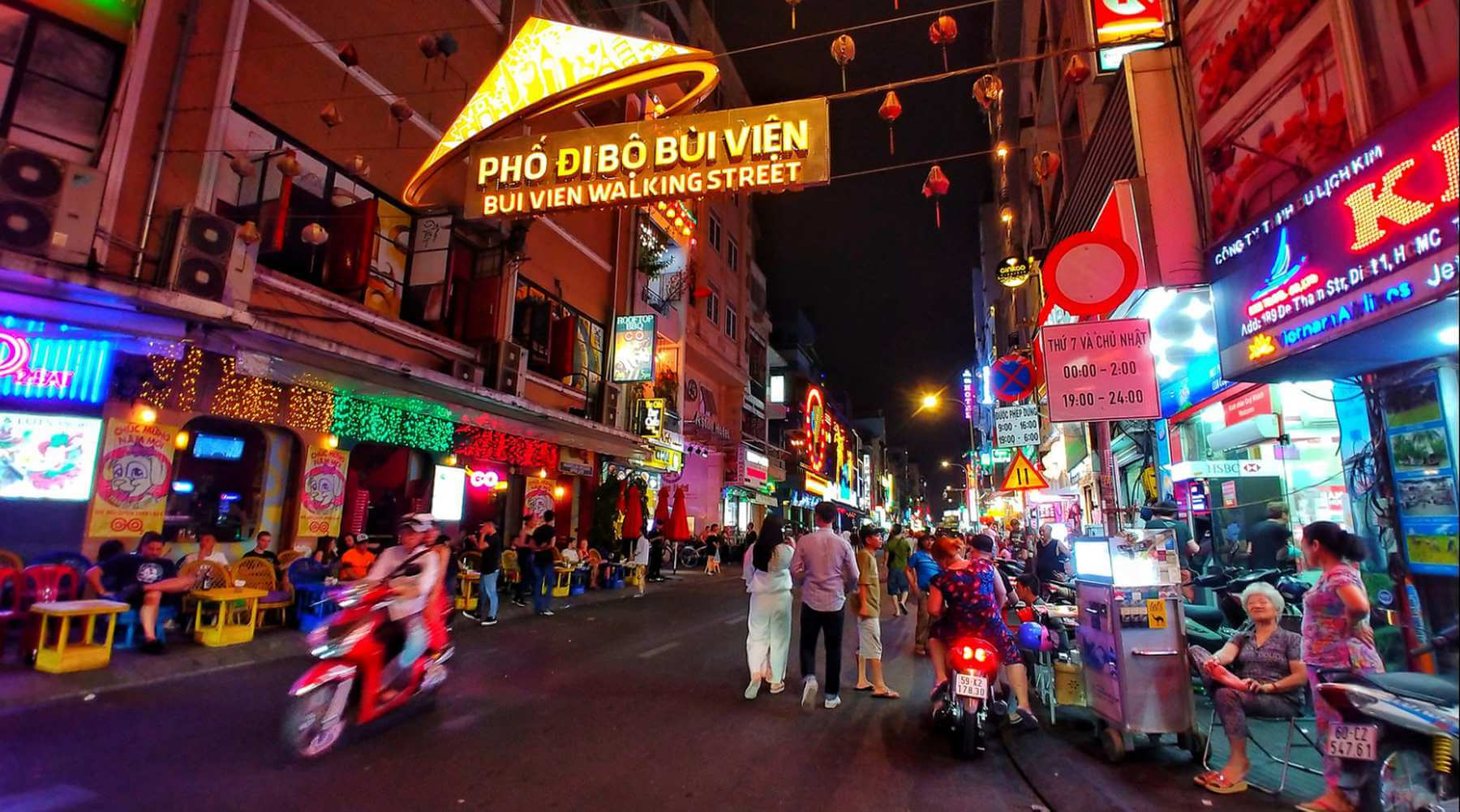 Crowded nightlife scene at Bui Vien Walking Street in Ho Chi Minh City with colorful neon lights, bars, restaurants, and people enjoying the vibrant atmosphere at night.