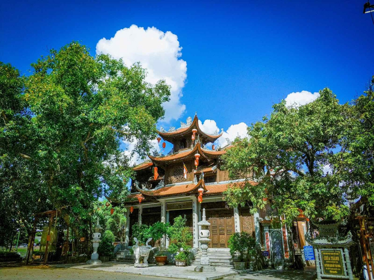 Traditional pagoda surrounded by green trees under a blue sky in Lang Son, northern Vietnam.