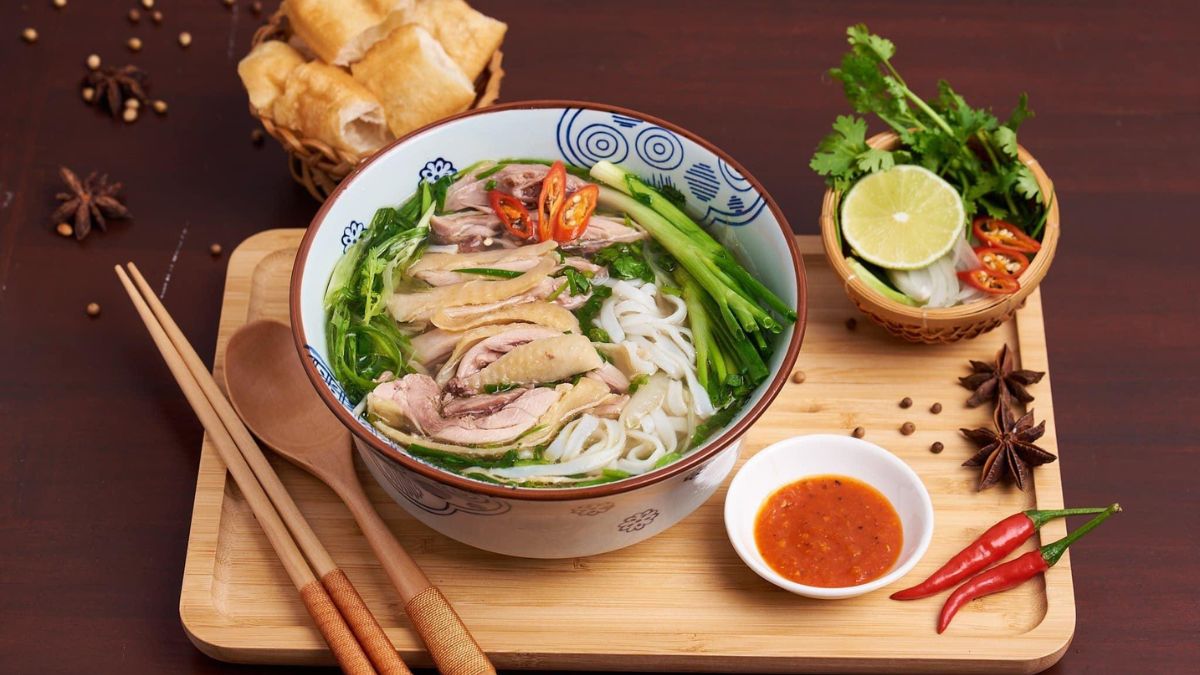 Traditional Vietnamese chicken pho served in a steaming bowl with tender chicken, rice noodles, fresh herbs, and flavorful broth.
