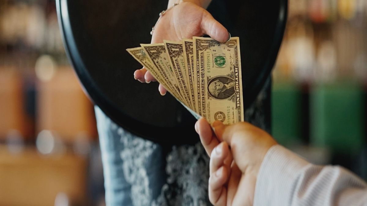 A customer leaving a tip at a restaurant after a meal to show appreciation for excellent service.