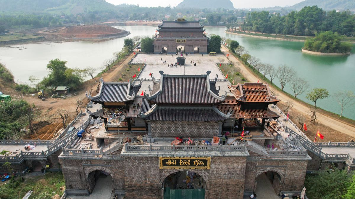 Aerial view of the Great Triple Gate at Tam Chuc Pagoda Complex, surrounded by tranquil lakes and limestone mountains in Ha Nam, Vietnam.