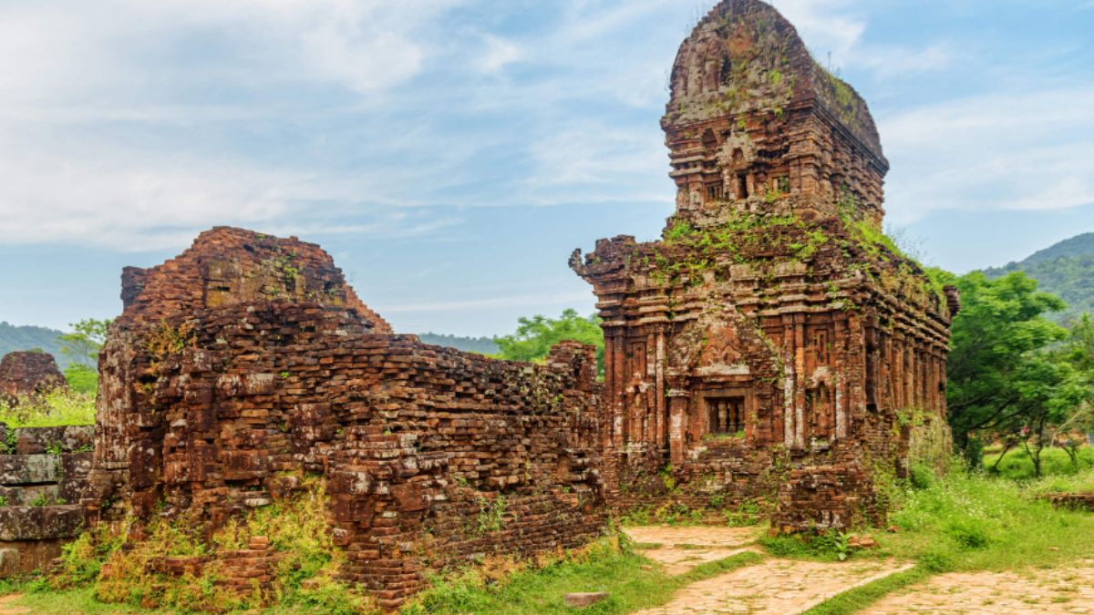 Ancient brick temples at My Son Sanctuary, a UNESCO World Heritage Site surrounded by lush green mountains in Central Vietnam.