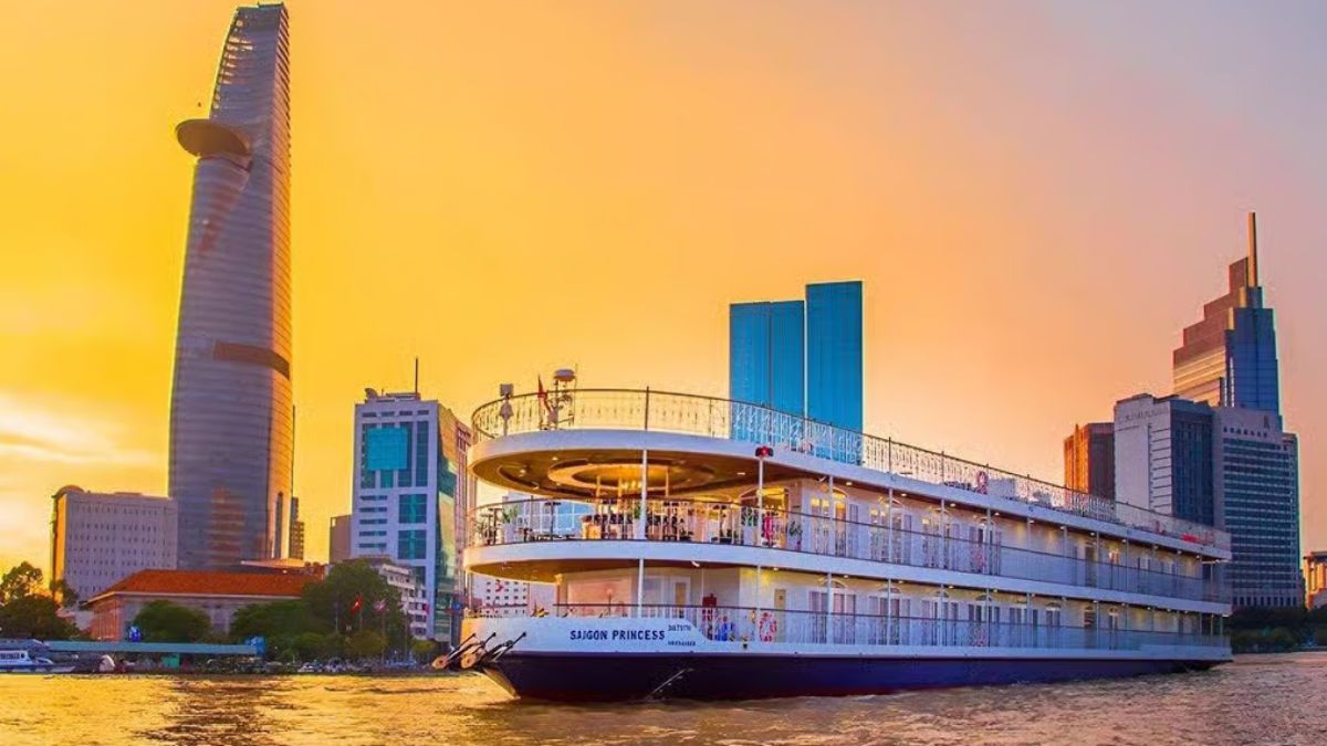 Luxury Saigon Princess dinner cruise sailing on the Saigon River at sunset, with the Ho Chi Minh City skyline and Bitexco Financial Tower in the background.