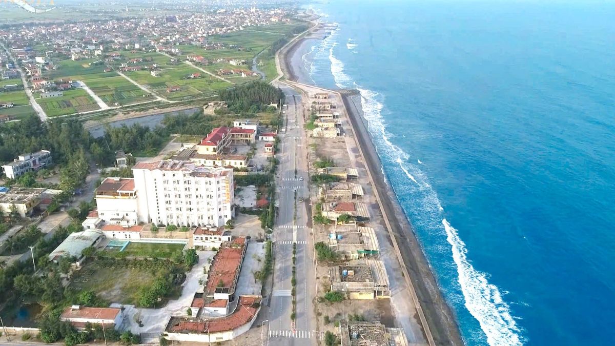 Clean sandy beach at Thinh Long Beach in Nam Dinh with gentle waves and visitors enjoying the seaside.