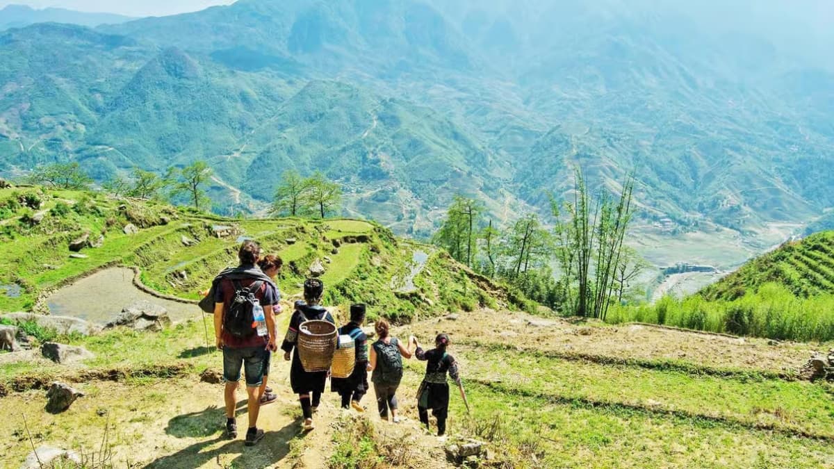 Tourists trekking through terraced rice fields in Sapa, Vietnam